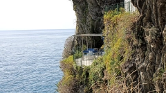 Private blue terrace seating on a steep cliffside balcony overlooking the Ligurian Sea in Cinque Terre, Italy.